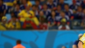 James Rodríguez (izq.) define de manera sutil ante la salida del portero de Japón, Eiji Kawashima, ayer en el Estadio Arena Pantanal  de Cuiabá.