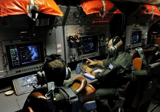 Tripulantes de un avión AP-3C Orion de la Real Fuerza Aérea Australiana trabajan en la búsqueda, en el sur del Océano Índico, del avión desaparecido de Malasya Airlines.