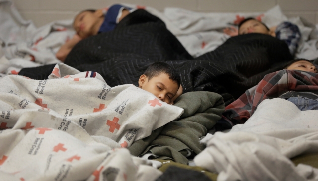 Niños migrantes duermen en un albergue temporal.
