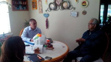 Rogelio Ruiz, de 85 años de edad, recibe en su hogar al conector comunitario de Molina Health Care, Ernesto Franco, quien le explica sus nuevos beneficios