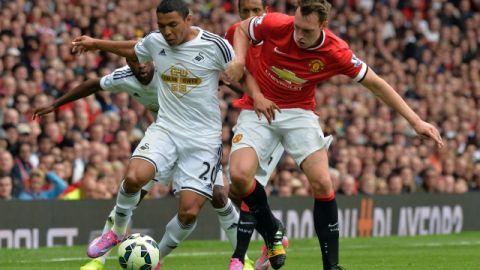 Jefferson Montero (izq.), del Swansea, intenta pasar frente a la marcación de Phil Jones en un trámite del partido disputado ayer en el estadio Old Trafford de Manchester.
