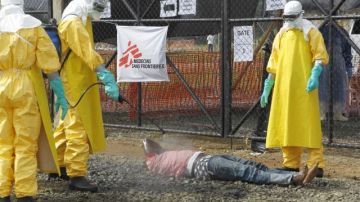 Enfermeros de Liberia desinfectan el cuerpo de una presunta víctima de ébola.