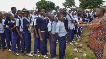 Estudiantes participan en una inspección de detección del virus del ébola en la escuela primaria Madonna, en Abuja,