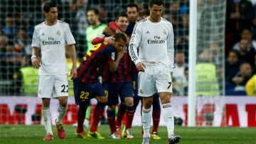 Con cristiano Ronaldo como testigo, Lionel Messi celebra el tercero de su tripleta en la victoria del Barcelona sobre el Real Madrid en el Bernabéu.