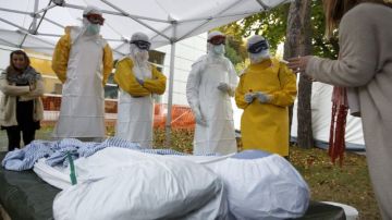 Trabajadores sanitarios de la Federación Internacional de la Cruz Roja (FICR) y de la ONG Médicos sin Fronteras realizan un entrenamiento práctico previo a su viaje a los países de África afectados por el ébola.