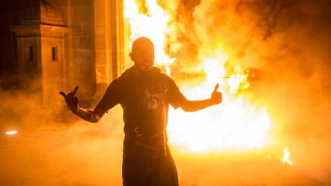 Un hombre posa para una foto delante de una puerta incendiada en el Palacio Nacional de México.
