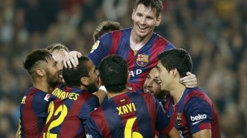 Lionel Andrés Messi (arriba) es felicitado por sus compañeros tras convertirse en el goleador histórico de Liga ayer, en el Camp Nou.