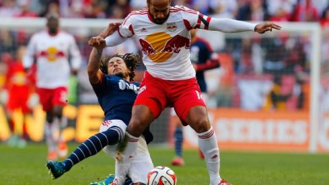 Thierry Henry supera la barrida defensiva de  Jermaine Jones    de New England.