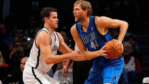 Dirk Nowitzki, de los Mavericks, defiende un balón ante Kris Humphries, de los Nets.