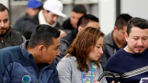 Varias personas estudian para pasar la prueba escrita para obtener la licencia de conducir en la oficina del DMV en Granada.
