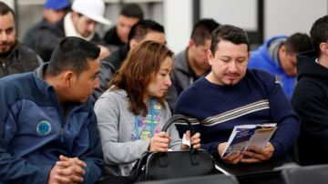 Varias personas estudian para pasar la prueba escrita para obtener la licencia de conducir en la oficina del DMV en Granada.