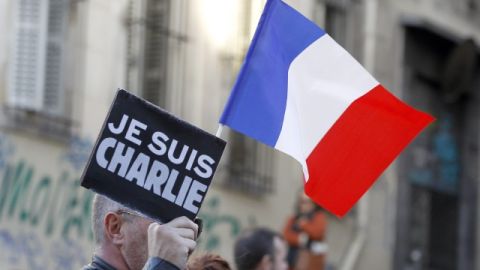 Un hombre con un cartel con el eslogan 'Je Suis Charlie' la bandera francesa participa en una de las múltiples manifestaciones realizadas ayer Francia.