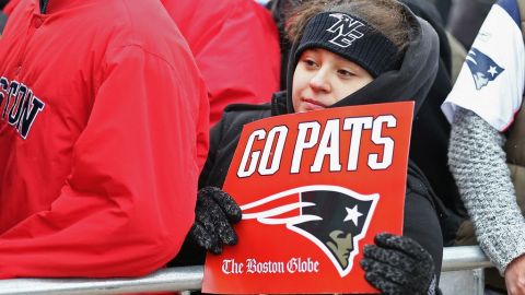 Un niño muestra un cartel de ánimo a los Patriots antes de que el equipo partiera rumbo a Arizona.