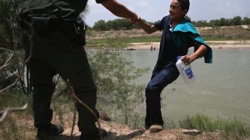 Un agente de la Patrulla Fronteriza asiste a un menor no acompañado de El Salvador, que cruzó el Río Grande el 24 de julio de 2014 en Mission, Texas.