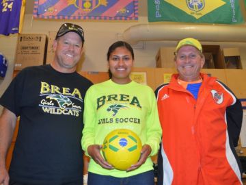 Kristen Avila junto al coach de la escuela, Mike Knaus (izq.), y su ex entrenador Manuel Toledo.