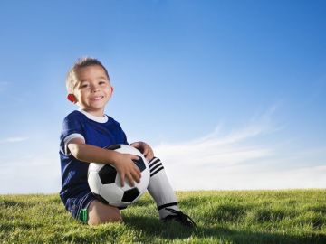 Los niños que practican deportes aprenden a trabajar en equipo para alcanzar un gol en común.