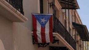 Con pancartas que imitaban una señal de tráfico para indicar un "prohibido el IVA", miles de personas entonaron hoy cánticos en contra de este impuesto en Puerto Rico.