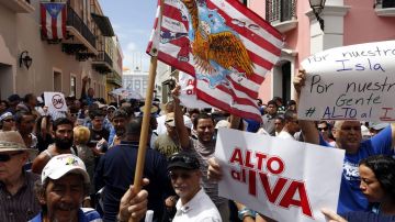Con pancartas que imitaban una señal de tráfico para indicar un "prohibido el IVA", miles de personas entonaron hoy cánticos en contra de este impuesto en Puerto Rico.