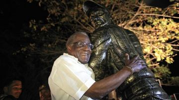 Orestes 'Minnie' Miñoso al lado de su estatua eb La Romana, República Dominicana.