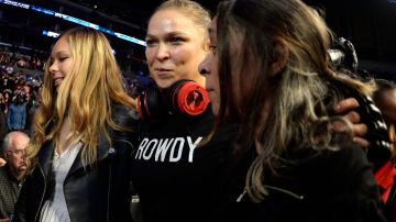 Ronda Rousey (c), acompañada por su madre AnnMaria Mars (d) y su hermana Julia, en su entrada al octágono en el Staples Center.