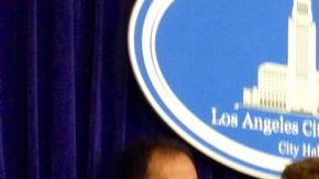 El concejal de Los Ángeles, Gil Cedillo, rodeado por inmigrantes, cuenta los detalles de la defensa por los alivios migratorios.