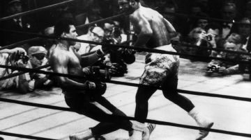 Ali (izq.) es derribado por un gancho de izquierda de Joe Frazier en el Madison Square Garden en marzo de 1971.
