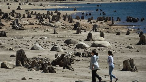 Dos mujeres caminan sobre lo que antes era parte del lago Huntington en California, que su nivel de agua ahora se encuentra a 30% de lo normal.