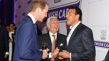 En la der., el cantante Lionel Richie charla con el Príncipe William, en la izq, en un evento. ¿Le habrá pedido un autógrafo o una selfie?.