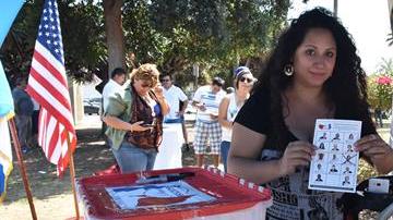 Maya Batres (i) muestra su papeleta electoral en las elecciones presidenciales simbólicas de la comunidad guatemalteca en Estados Unidos, en Los Ángeles, California