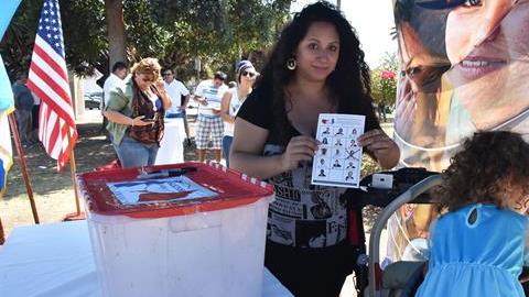 Maya Batres (i) muestra su papeleta electoral en las elecciones presidenciales simbólicas de la comunidad guatemalteca en Estados Unidos, en Los Ángeles, California