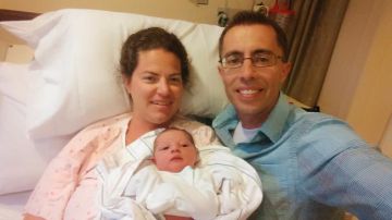Rachel (izq.) y su esposo Robert Grindstaff posan con su bebito ya en el resguardo de un hospital.