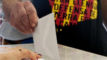 Un hombre deposita su voto en un colegio electoral de Vic, Barcelona