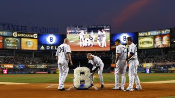 El manager de los Yankees Joe Girardi y sus tres receptores en el equipo le rinden tributo a Yogi berra con un arreglo floral con la forma del número 8 detrás del home.