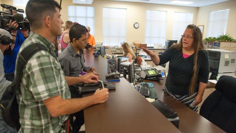 Robbie Blankenship (Izq.) junto a su pareja de 20 años,  Jesse Cruz, de Corpus Christie, Texas, hablan con la secretaria del condado de Rowan, Kim Davis.