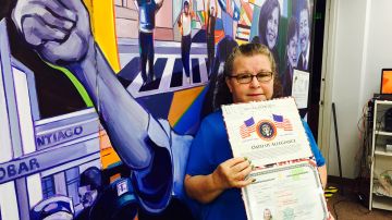 Meydey Flores muestra su certificado de ciudadania de Estados Unidos.