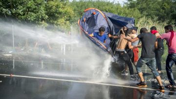 La Policía húngara contiene a los inmigranets con agua a presión.