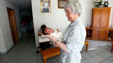 Adelia Contini, Directora del Instituto Madre Assunta, cuida de un bebé recién nacido de "Maria", una mujer que embarazada pretenda cruzar la frontera pero su hija nació en Tijuana./AURELIA VENTURA