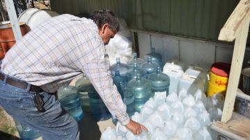 Jimmy Moreno revisando los recipientes donde almacena agua.