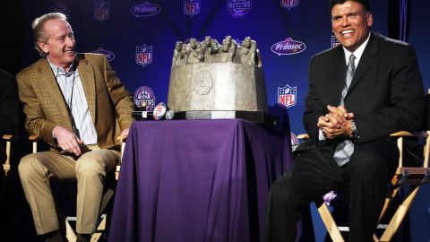 Anthony Muñoz (der.), aquí en un evento de la NFL con Archie Manning, el padre de Peyton y Eli, dedica su tiempo a enseñar el deporte del futbol americano a niños y jóvenes.