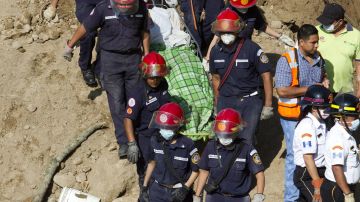 Rescatistas recuperan un cadáver tras el deslizamiento de tierra del pasado jueves, en la aldea Cambray II, en Santa Catarina Pinula