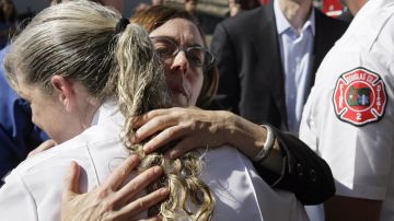 La gobernadora interina de Oregon  Kate Brown abraza a uno de los rescatistas de la tragedia.