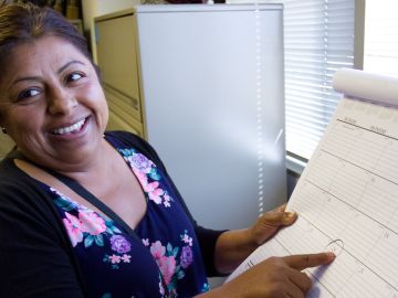La inmigrante mexicana Olivia Ortiz Chávez sonríe al escuchar información sobre la nueva ley que le permitirá pedir un perdón por haber vivido como indocumentada.
