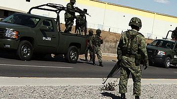 Policías miliatres guardan el lugar donde se cometió un homicidio en Juárez, México.
