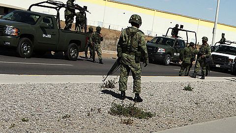Policías miliatres guardan el lugar donde se cometió un homicidio en Juárez, México.