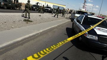 Policías miliatres guardan el lugar donde se cometió un homicidio en Juárez, México.