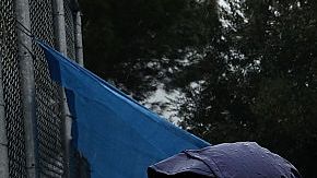 Refugiados bajo la lluvia en un campamento superpoblado en la isla de Lesbos, en Grecia.