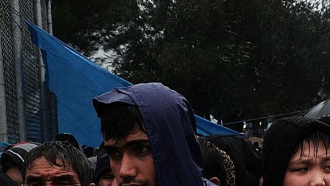 Refugiados bajo la lluvia en un campamento superpoblado en la isla de Lesbos, en Grecia.