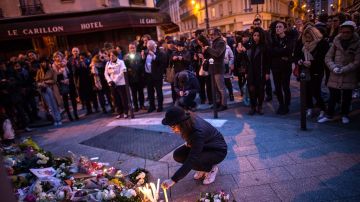 Una persona deposita flores ante el restaurante The Petit Cambodge, uno de los lugares que sufrió ataques terroristas en París.