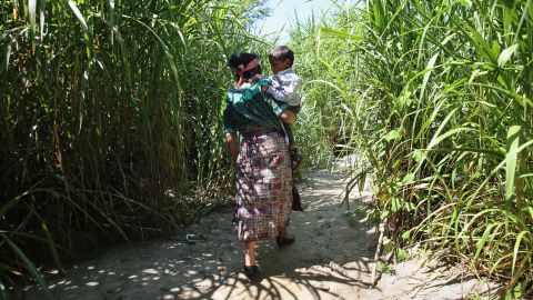 Miembros de una familia guatemalteca caminan en territorio mexicano tras cruzar la frontera ilegalmente.