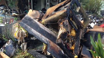 Artículos quemados se muestran afuera de la casa incendiada en Carson. /ISAÍAS ALVARADO